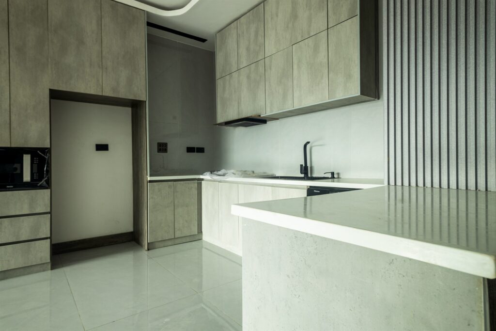 Brum Height 8: Fitted kitchen with pale wood-tone cabinets and a breakfast counter